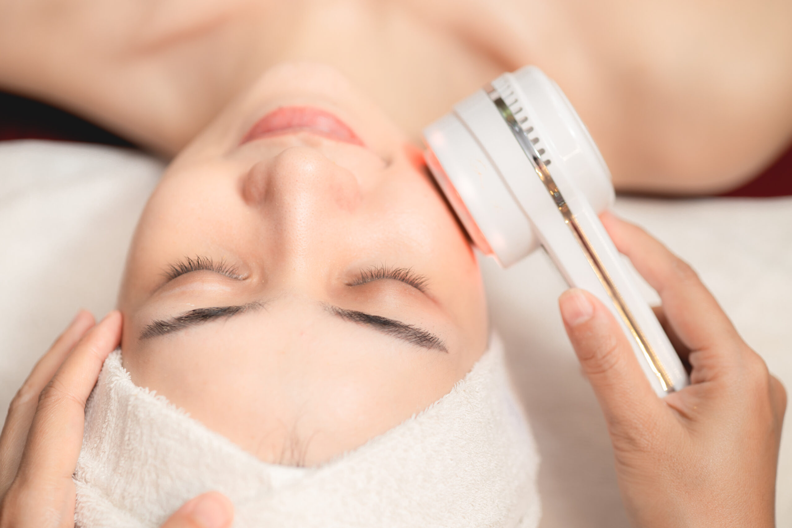 closeup people using Ultrasonic massage device for Facial Lifting Activate Collagen and Skin Tightening in beauty salon spa.
